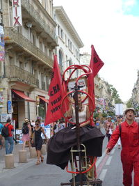 People on street against buildings in city