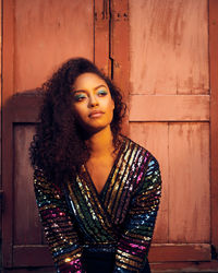 Portrait of beautiful woman standing against wall