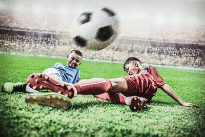 Young man playing soccer ball on grass