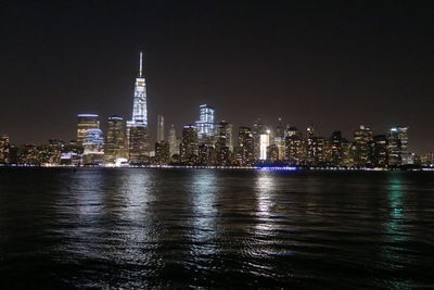 Illuminated cityscape in front of hudson river at night