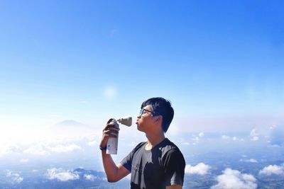 Man photographing against sky