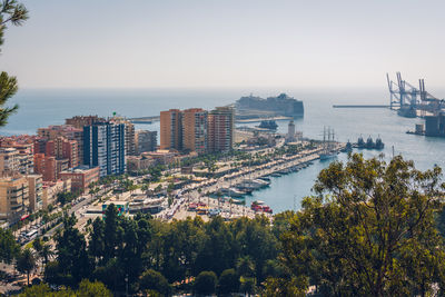 High angle view of buildings and sea against clear sky