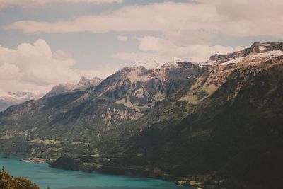 Scenic view of lake by mountains against sky