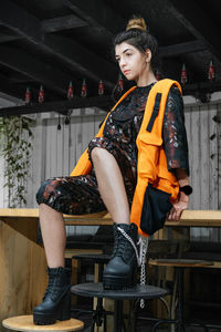 Low angle view of young woman looking away while sitting on table in cafe