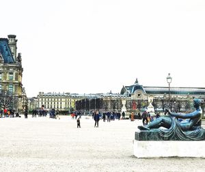 Statue in city against clear sky