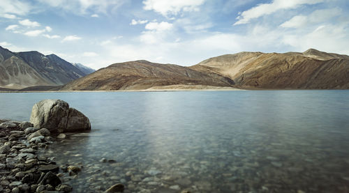 Scenic view of sea and mountains against sky