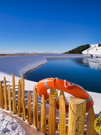 An orange lifesaver of a water reservoir for snow production in the italian dolomites