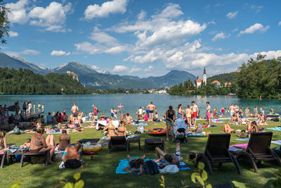 People sitting on table by mountains against sky