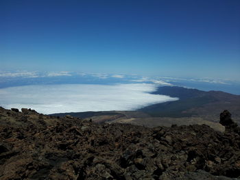 Scenic view of sea and mountains against clear blue sky