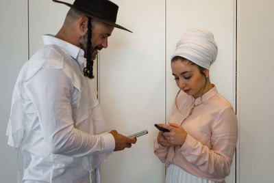 Friends in traditional clothing using mobile phone