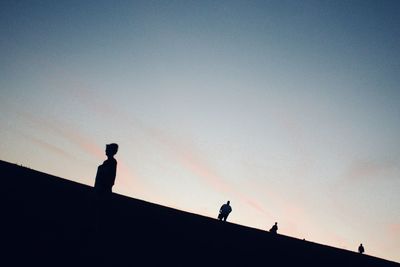 Low angle view of silhouette man standing against clear sky