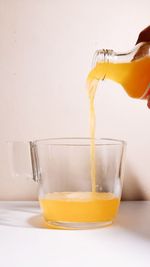 Close-up of hand pouring drink in glass