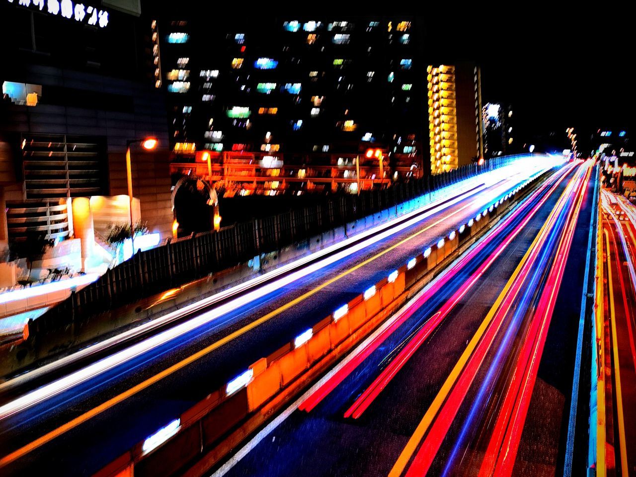 LIGHT TRAILS ON ROAD IN CITY