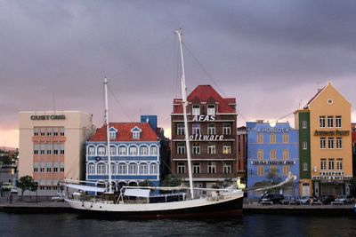 Boats moored in city against sky