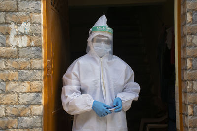 Doctor in ppe kit at standing at the door