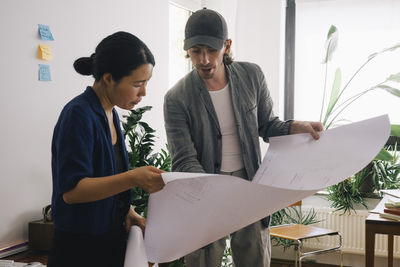 Multiracial architect colleagues discussing over design at home office