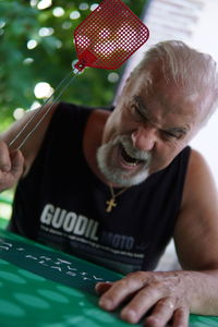 Close-up of angry man holding equipment