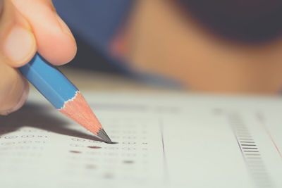 Close-up of hand holding pencil on paper