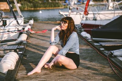 Full length of young woman sitting on boat