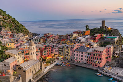 High angle view of town by sea against sky