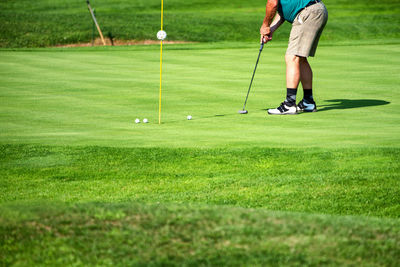 Low section of man playing with ball on grass