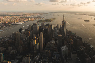 High angle view of cityscape by river during sunset