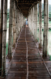 Woman walking on wooden walkway