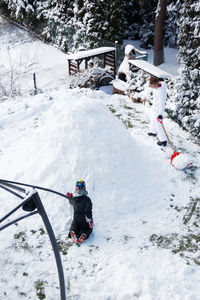 View of two kids building a snow igloo in winter