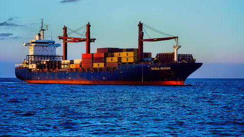 Commercial dock by sea against blue sky