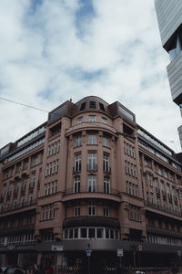 Low angle view of buildings against cloudy sky