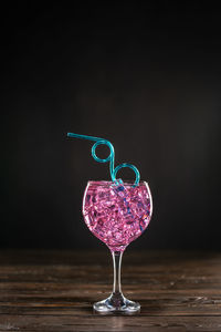 Close-up of wine glass on table against black background