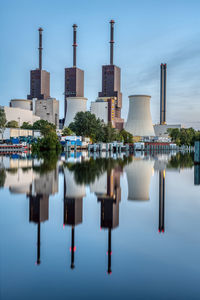 A thermal power station in berlin at dusk reflected in a canal