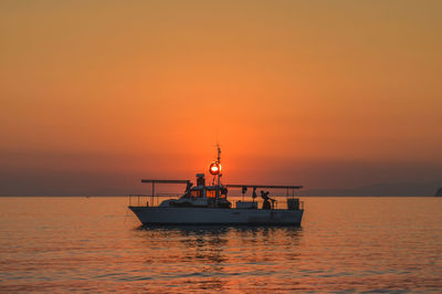 Boat on sea against sky during sunset