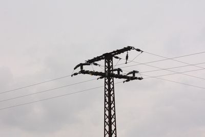 Low angle view of electricity pylon against sky