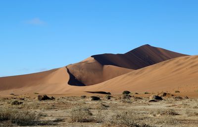 Scenic view of desert against clear blue sky