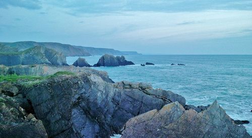 Scenic view of rocks in sea against sky