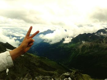 Cropped image of man standing on mountain against sky