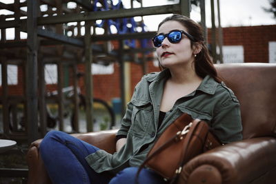 Portrait of young woman sitting in sunglasses