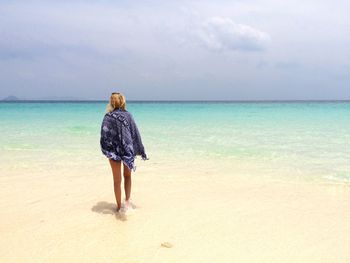 Rear view of woman standing on beach