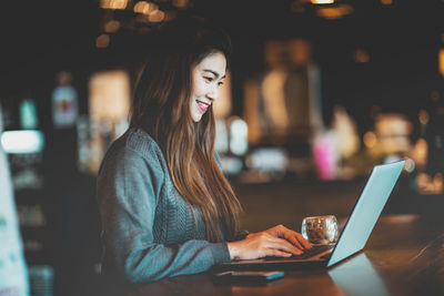 Young woman using mobile phone in cafe