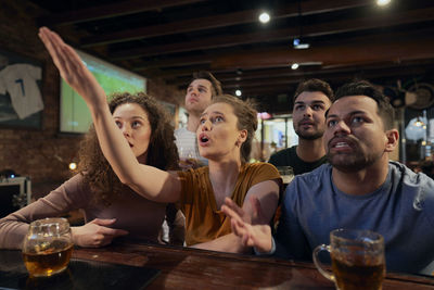 Happy friends watching soccer match at bar