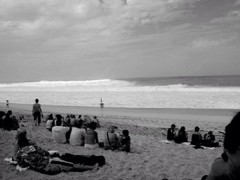 People at beach against sky