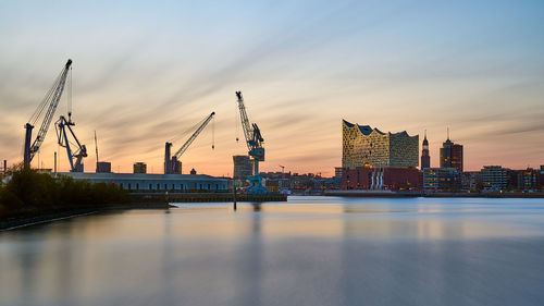 Hamburg skyline with the elbphilharmony and cranes at the port.