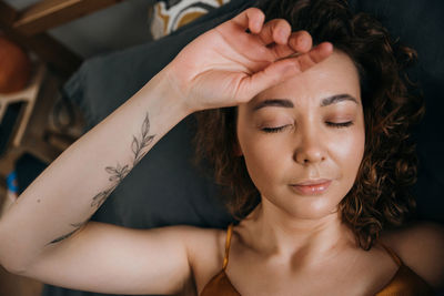 Close-up portrait of young woman on pillow