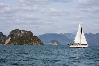 Sailboat sailing on sea against sky