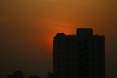 Silhouette buildings against sky during sunset