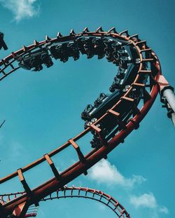 Low angle view of rollercoaster against blue sky