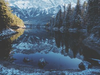 Scenic view of lake by snowcapped mountains during winter