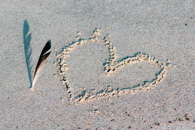 Close-up of heart shape on sand