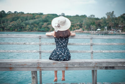 Rear view of woman standing by railing